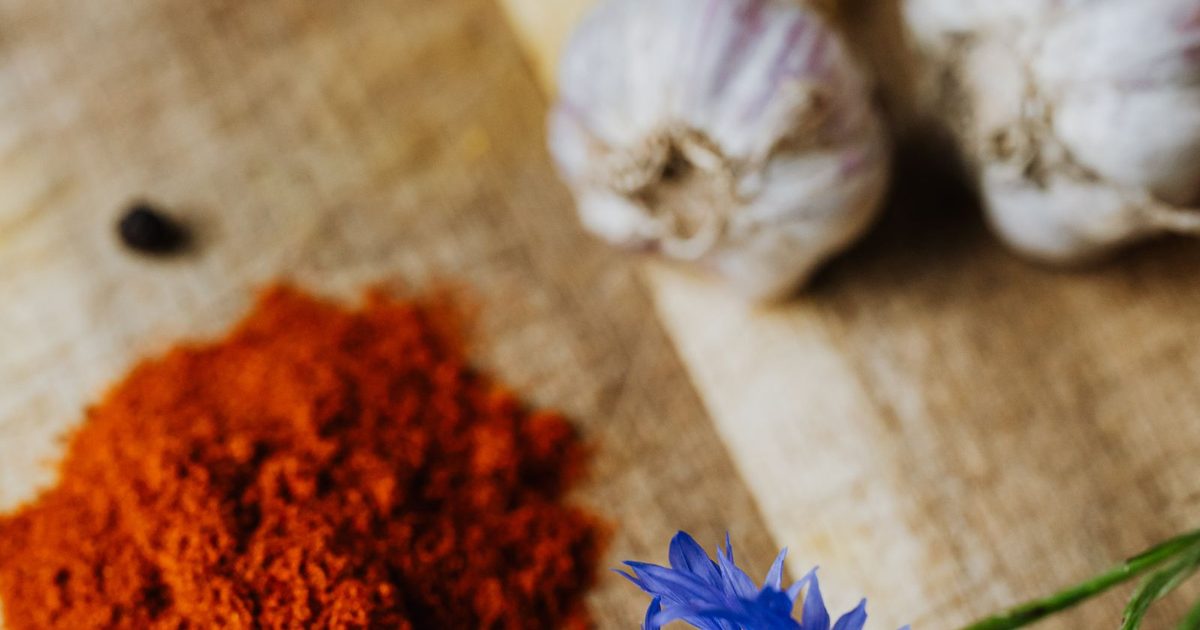 Colourful spices and garlic cloves on a rustic wooden surface